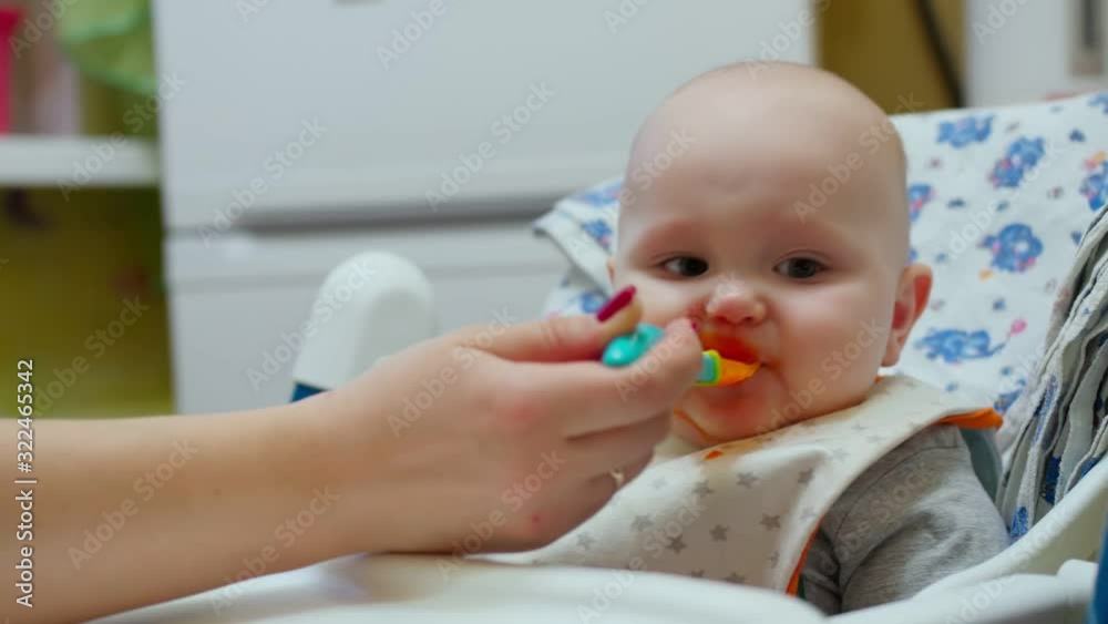 Mother feeding little baby with vegetable mash at home kitchen. Mother feeding little baby with vegetable mash at home kitchen.