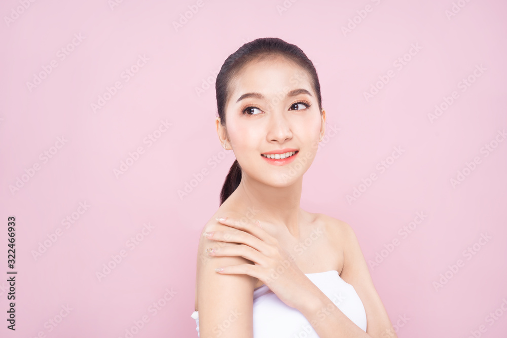 Beautiful Young Asian woman with clean fresh white skin face in beauty pose. Girl touching shoulder with finger isolated background. Facial treatment, cosmetic, spa, make up, plastic surgery concept. Beautiful Young Asian woman with clean fresh white skin face in beauty pose. Girl touching shoulder with finger isolated background. Facial treatment, cosmetic, spa, make up, plastic surgery concept.