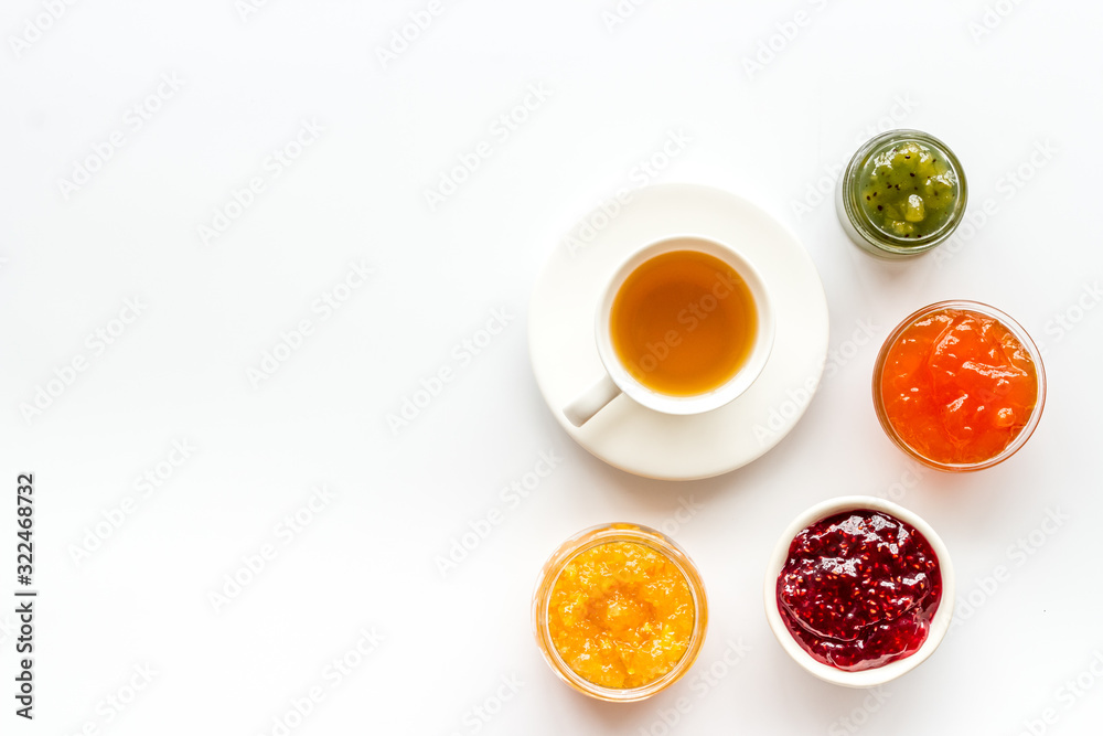 Fruit jam near tea on white kitchen desk frame copy space Fruit jam near tea on white kitchen desk frame copy space