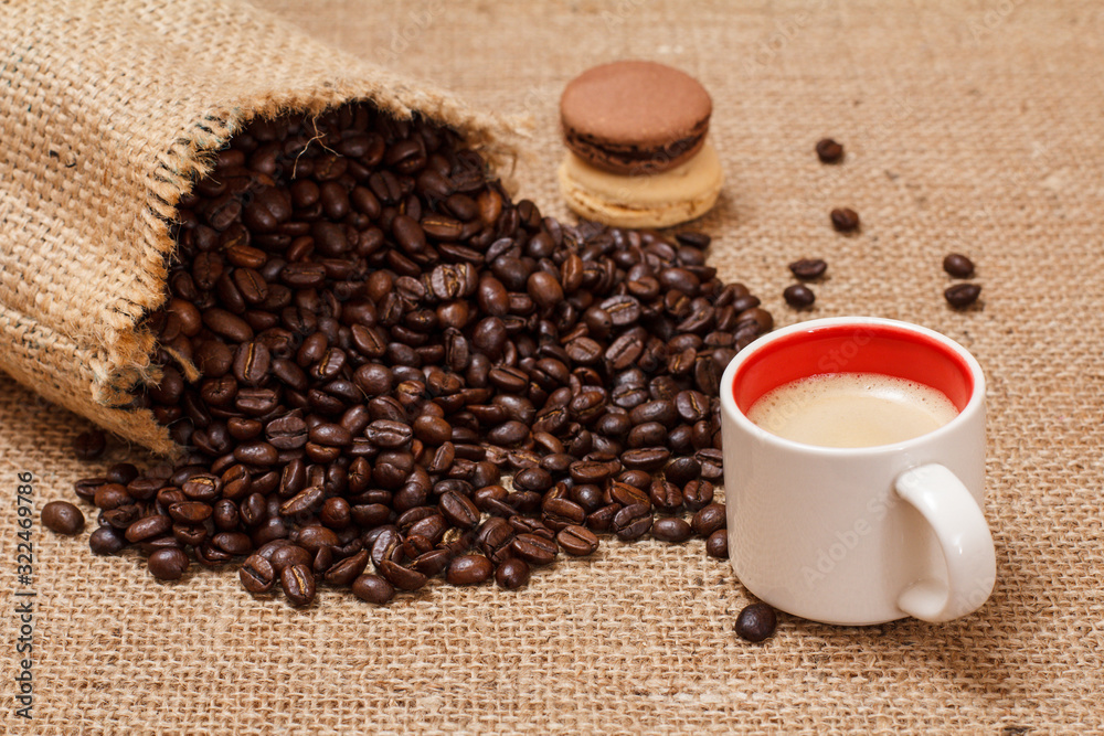 Fototapeta premium Cup of coffee and roasted coffee beans in a canvas sack.