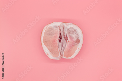 Sliced pomelo on a pink background, the concept of a female vagina photo