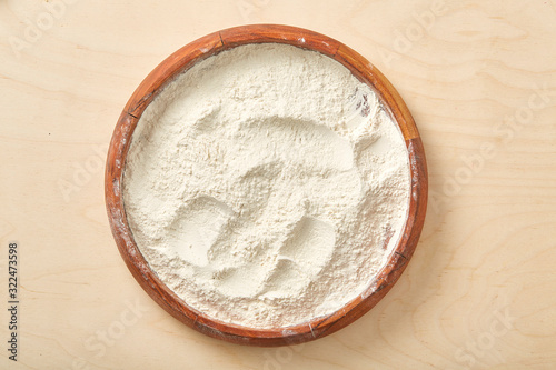 Flour in wooden bowl on a worktop. Close up.