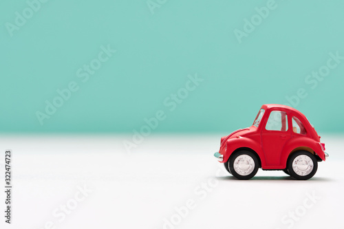 Side view of a red toy car on blue background