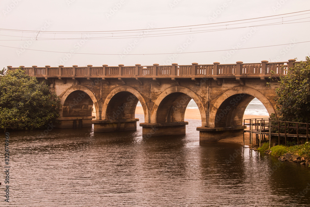 River Flowing Under Arched Railway Bridge
