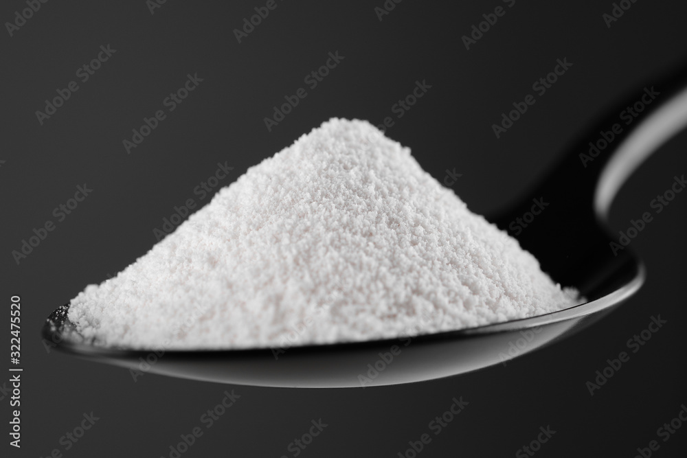collagen powder in black spoon. grey background closeup. Natural beauty and health supplement collagen powder in black spoon. grey background closeup. Natural beauty and health supplement