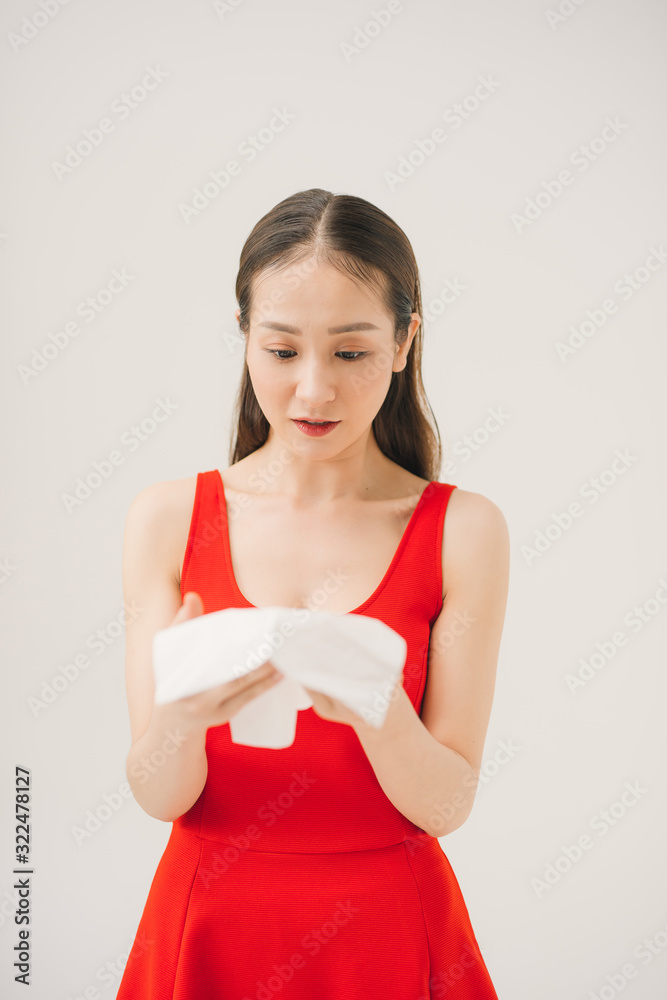 Woman with a cold blowing her runny nose with tissue. Woman with a cold blowing her runny nose with tissue.