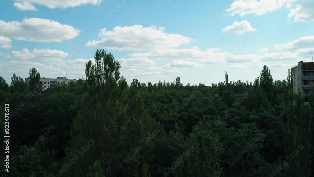 Aerial view of abandoned buildings and streets overgrown with trees in city Pripyat near Chernobyl nuclear power plant. Exclusion Zone. 4K drone footage. Aerial view of abandoned buildings and streets overgrown with trees in city Pripyat near Chernobyl nuclear power plant. Exclusion Zone. 4K drone footage.
