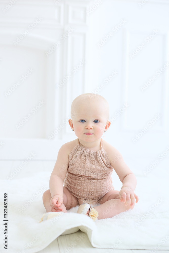 vertical photo of a baby sitting on the floor in a white studio vertical photo of a baby sitting on the floor in a white studio