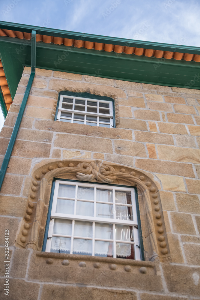 Detailed view of classic building with a gothic ornamented window, portuguese manuelino style, stone facade