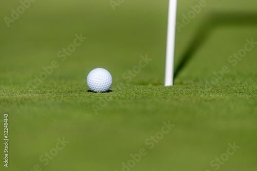 Golf Ball on Green Near Golf Hole