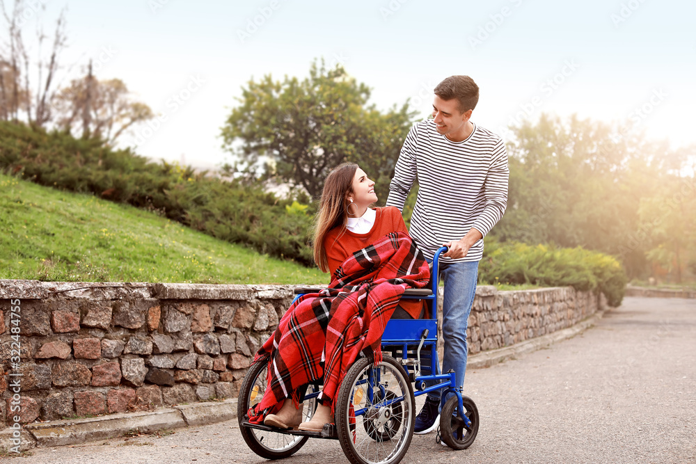 Handicapped young woman and her husband in autumn park Handicapped young woman and her husband in autumn park