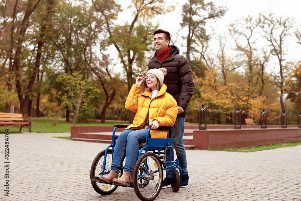 Handicapped young woman and her husband in autumn park Handicapped young woman and her husband in autumn park