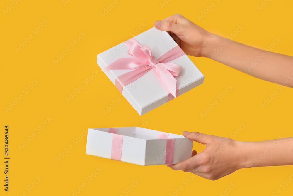 Female hands with beautiful gift box on color background Female hands with beautiful gift box on color background