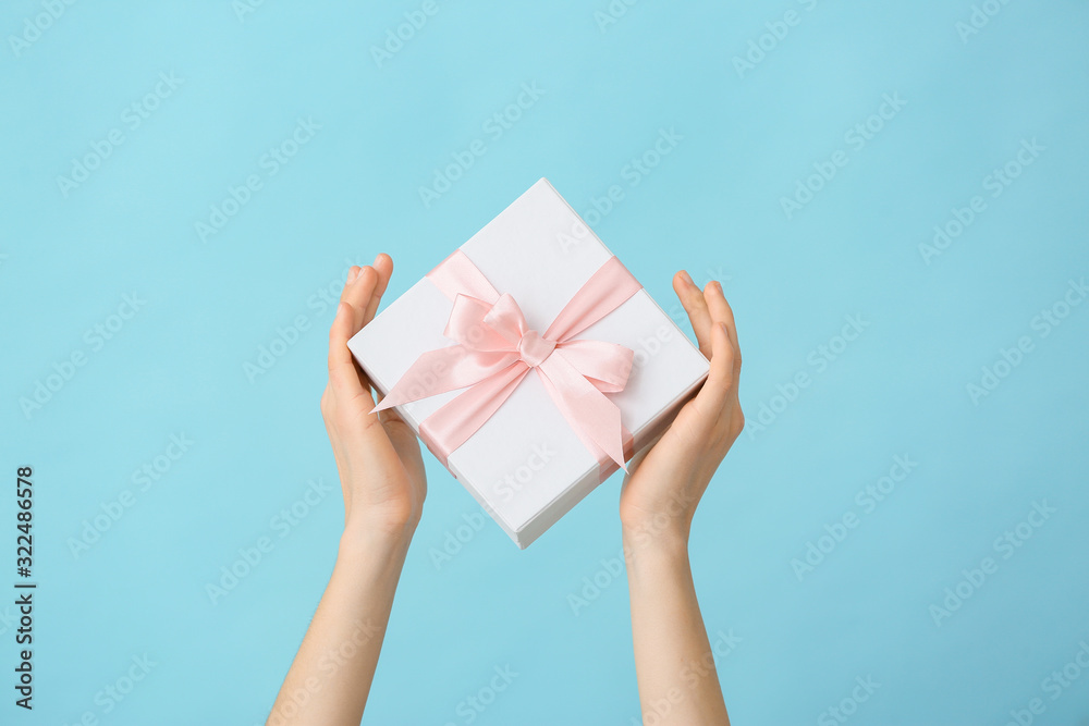 Female hands with beautiful gift box on color background Female hands with beautiful gift box on color background