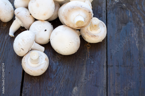 Fresh white Champignon mushrooms on vintage wood table background