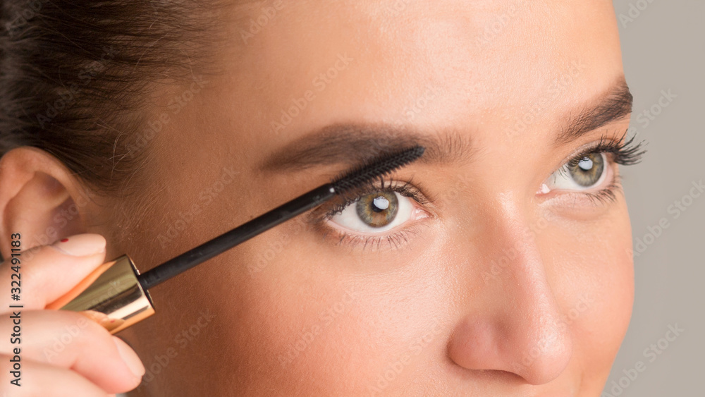 Woman combing her eyebrows with brow brush