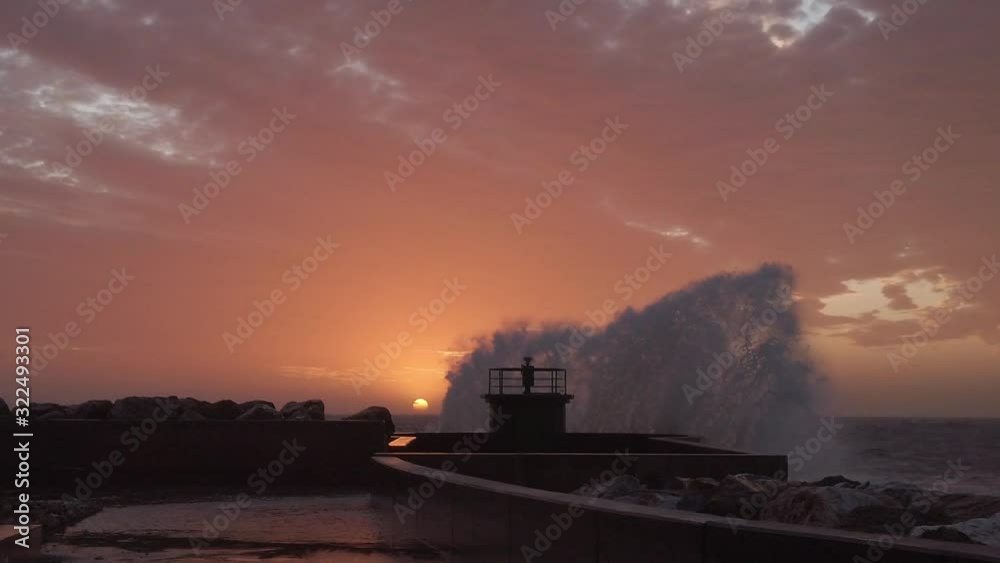 Schizzi e spruzzi del mare che si infrangono sul faro del porto al tramonto. Super slow motion. Schizzi e spruzzi del mare che si infrangono sul faro del porto al tramonto. Super slow motion.