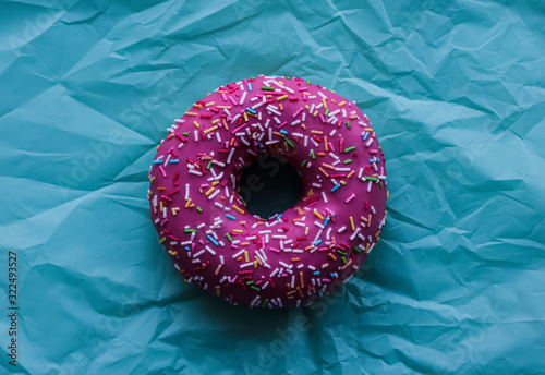pink donut with colored sprinkles on a blue background