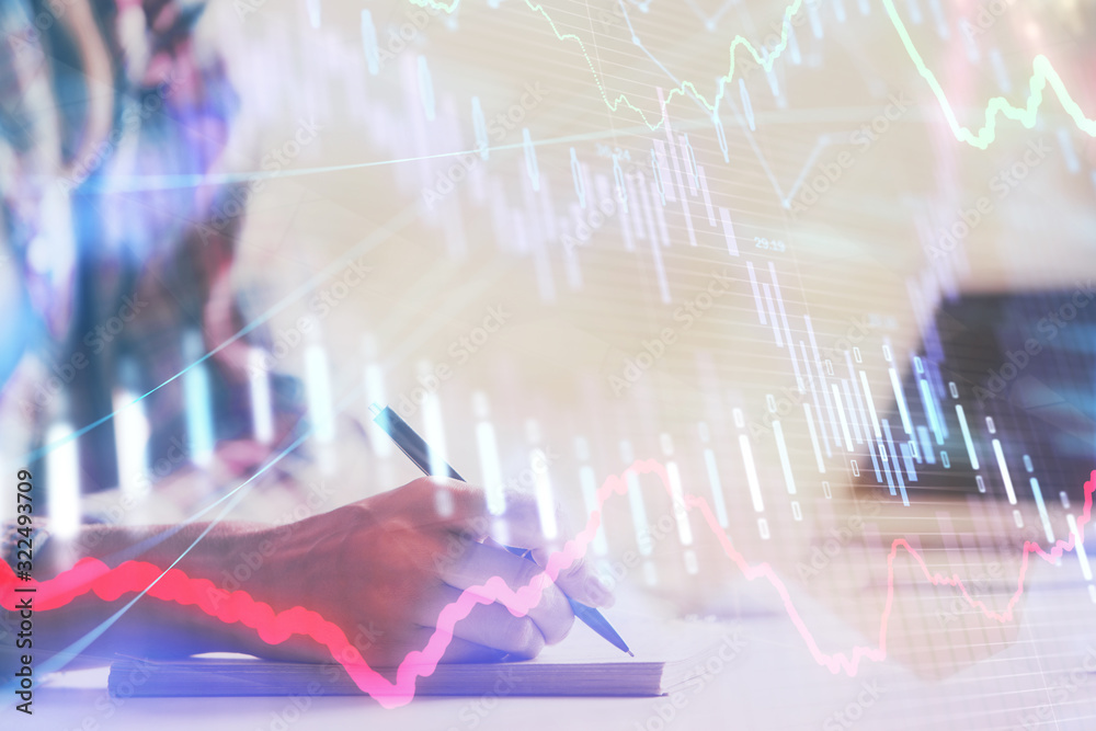 A woman hands writing information about stock market in notepad. Forex chart holograms in front. Concept of research. Double exposure A woman hands writing information about stock market in notepad. Forex chart holograms in front. Concept of research. Double exposure