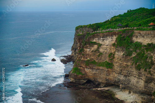 A beautiful ocean in Bali. The Pacific Ocean with large waves and tides that break on the rocks. The Indian Ocean is blue. Aqua Mente and Phantom Blue. Golden sunset on the ocean on the island of Bali