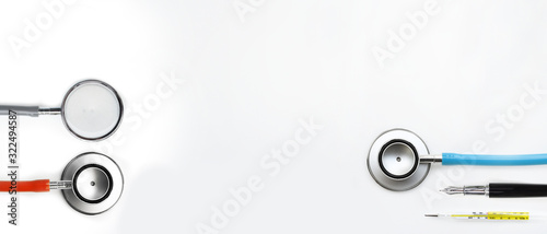 close up of stethoscope with pen and thermometers isolated on white background
