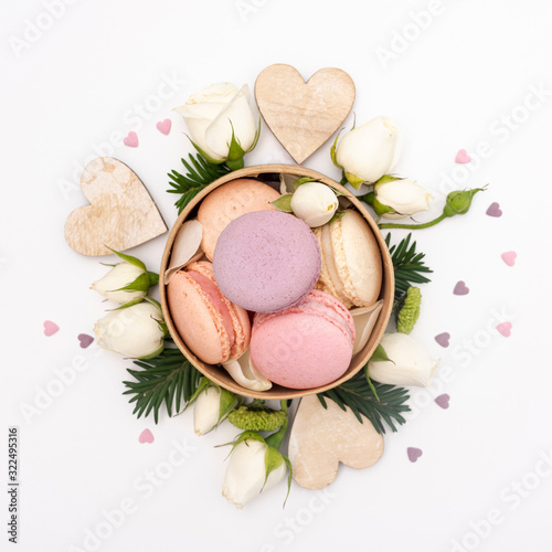 Flat lay of bowl with macarons and roses