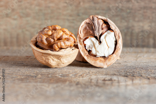 Close-up healthy chopped and unshelled walnuts on a wooden old table. Vegetarian food