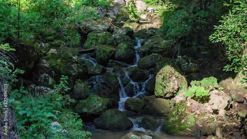 Stream in Huda Luknja flowing in slow motion. Shot during Summer in Dolic, Slovenia. Camera slowly pans down. photo