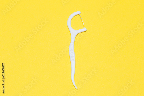 Fototapeta Naklejka Na Ścianę i Meble -  Plastic toothpick on a yellow isolated background. Hygiene and dental care.