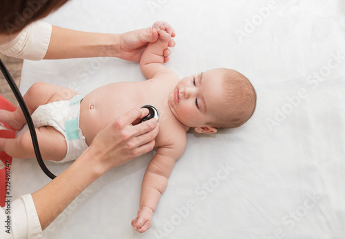 Pediatrician listens to newborn. physical examination of a small child