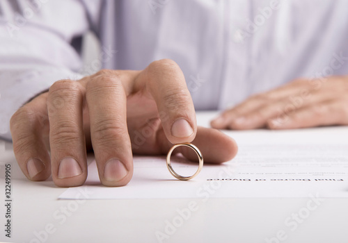Woman signing divorce decree and taking off wedding ring