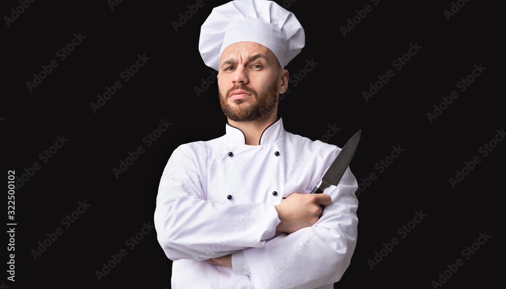 Serious Chef Holding Knife Looking At Camera Posing, Studio Shot Serious Chef Holding Knife Looking At Camera Posing, Studio Shot