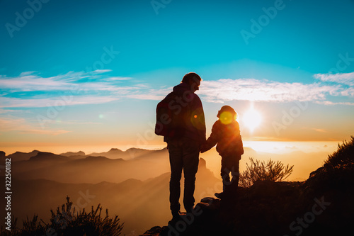father and little daughter travel in mountains at sunset © nadezhda1906