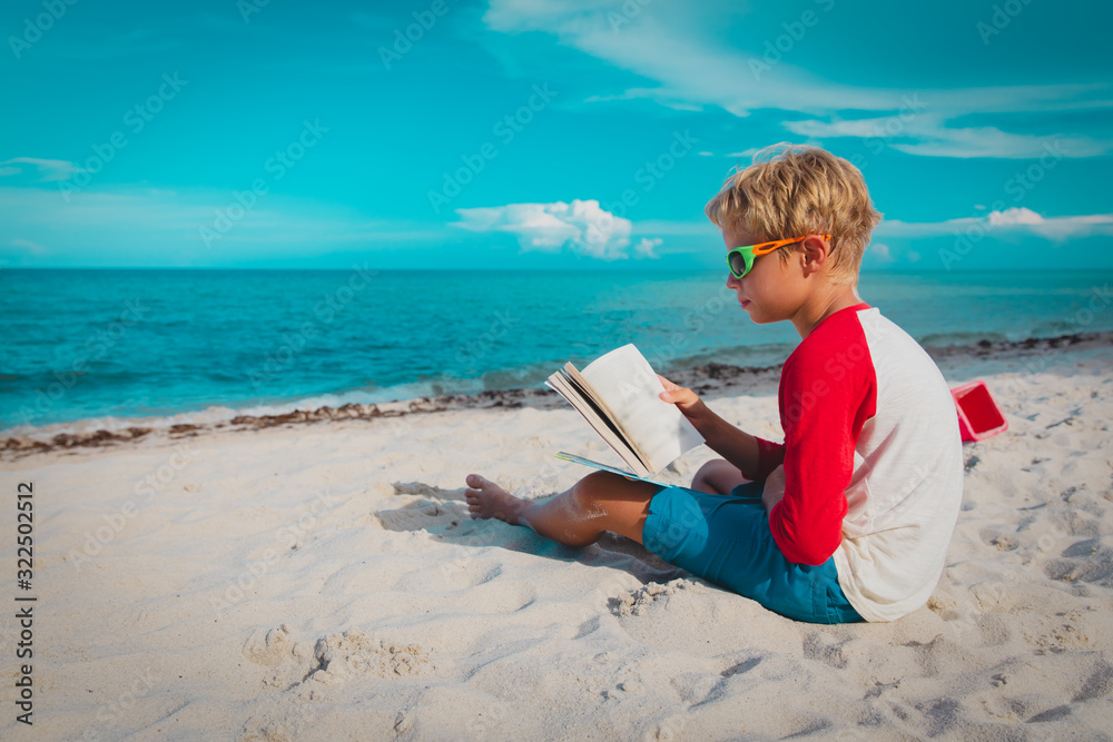 boy reading book at sand beach, kid learning on vacation