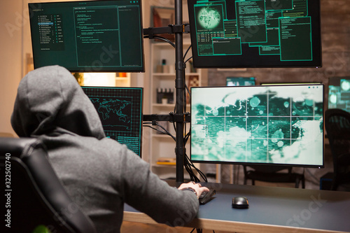 Quadro em tela Cyber criminal wearing a hoodie writing a dangerous virus