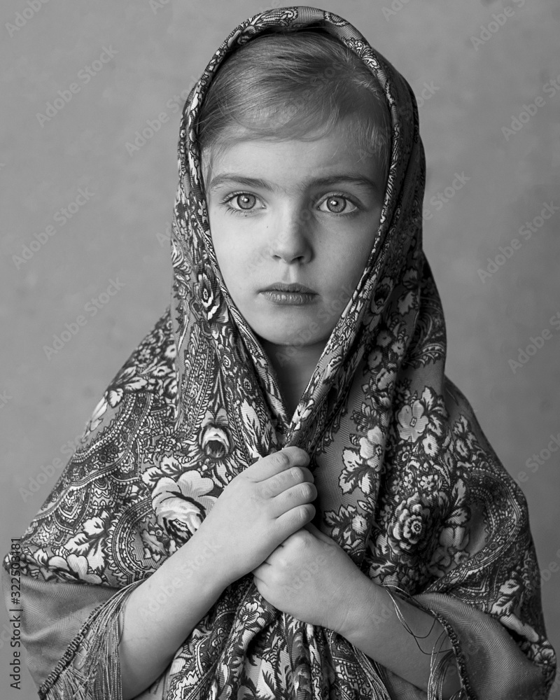 Little girl in a retro scarf thinks about God