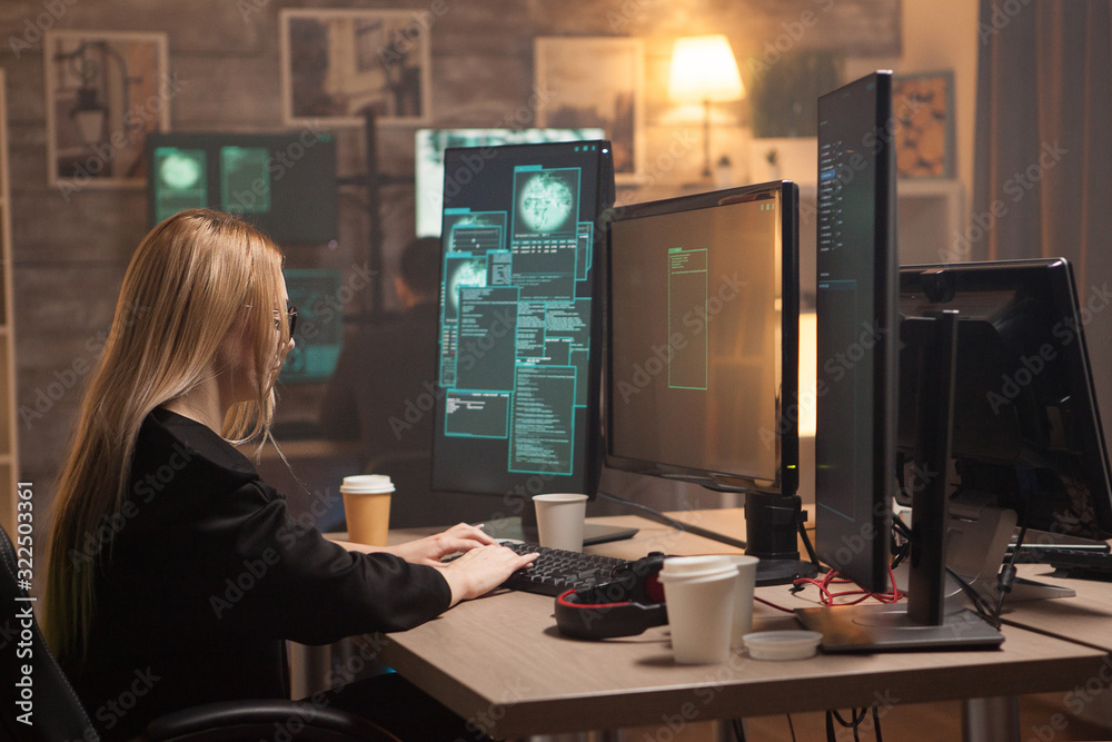 Dangerous female hacker writing a virus on computer Dangerous female hacker writing a virus on computer