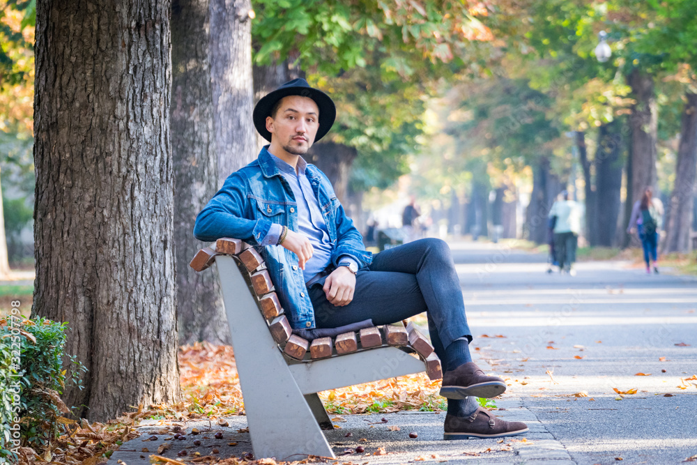 Portrait of a confident and successful young man with a denim jacket and blue shirt outside. Handsome young man outside
