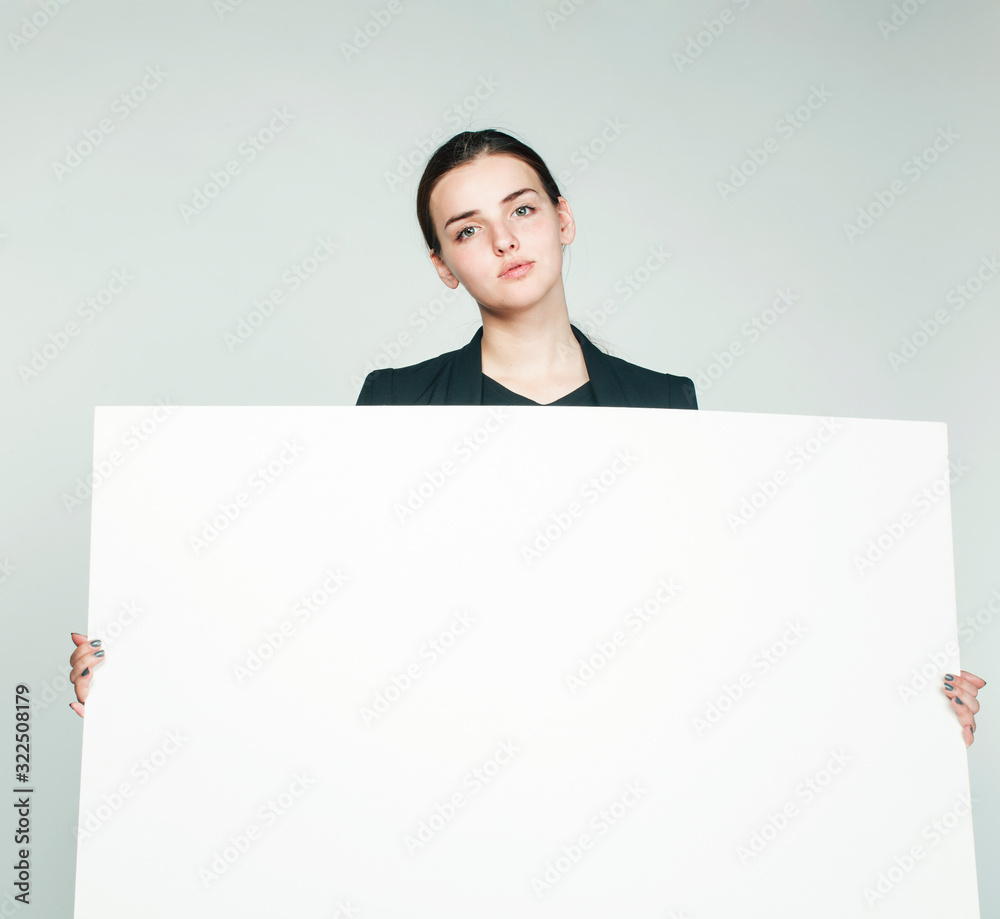young pretty brunette girl with placard on white background wearing business costume student, lifestyle people concept young pretty brunette girl with placard on white background wearing business costume student, lifestyle people concept