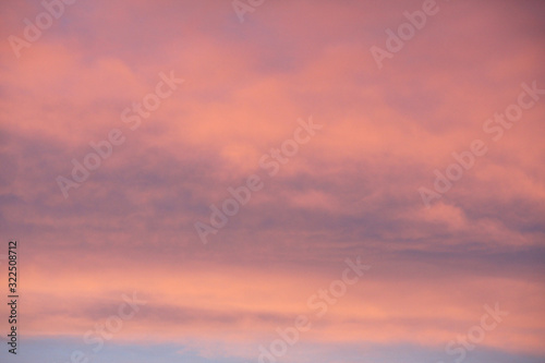 Dreamy evening sky in pastel tones with fluffy pink clouds at sunset