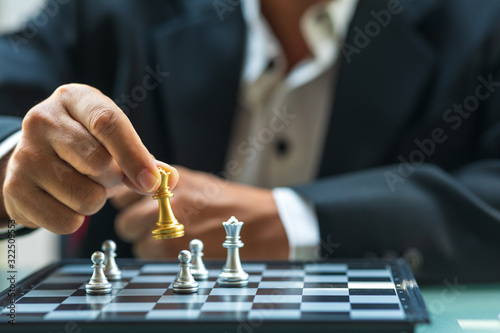 Business man holding The king chess for finishing the game