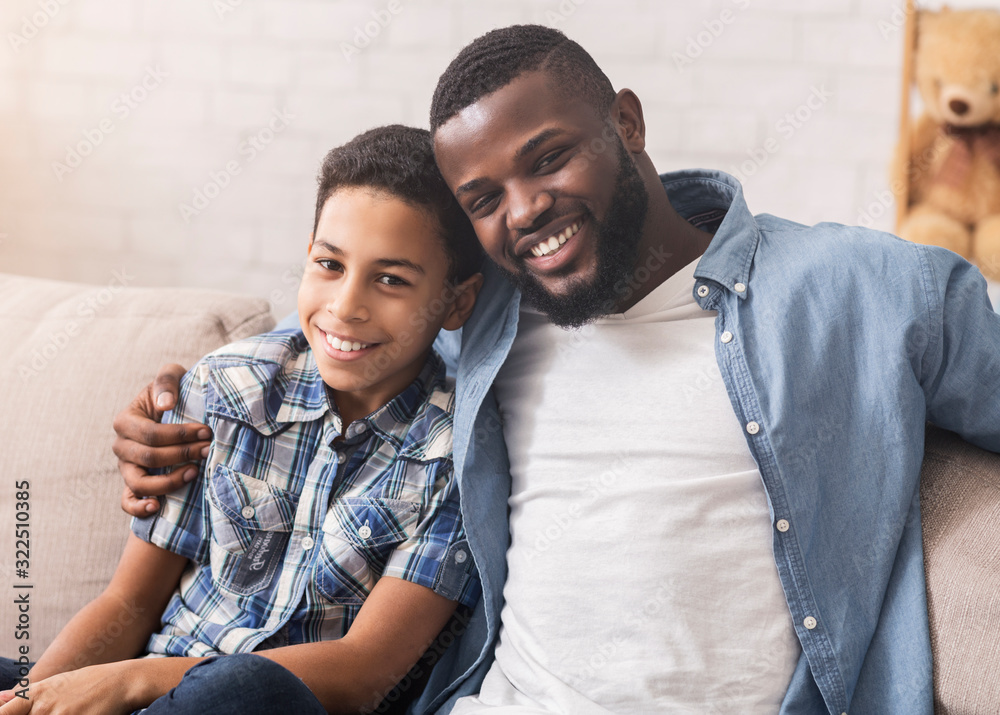 Obraz premium Happy african american father and son taking selfie at home