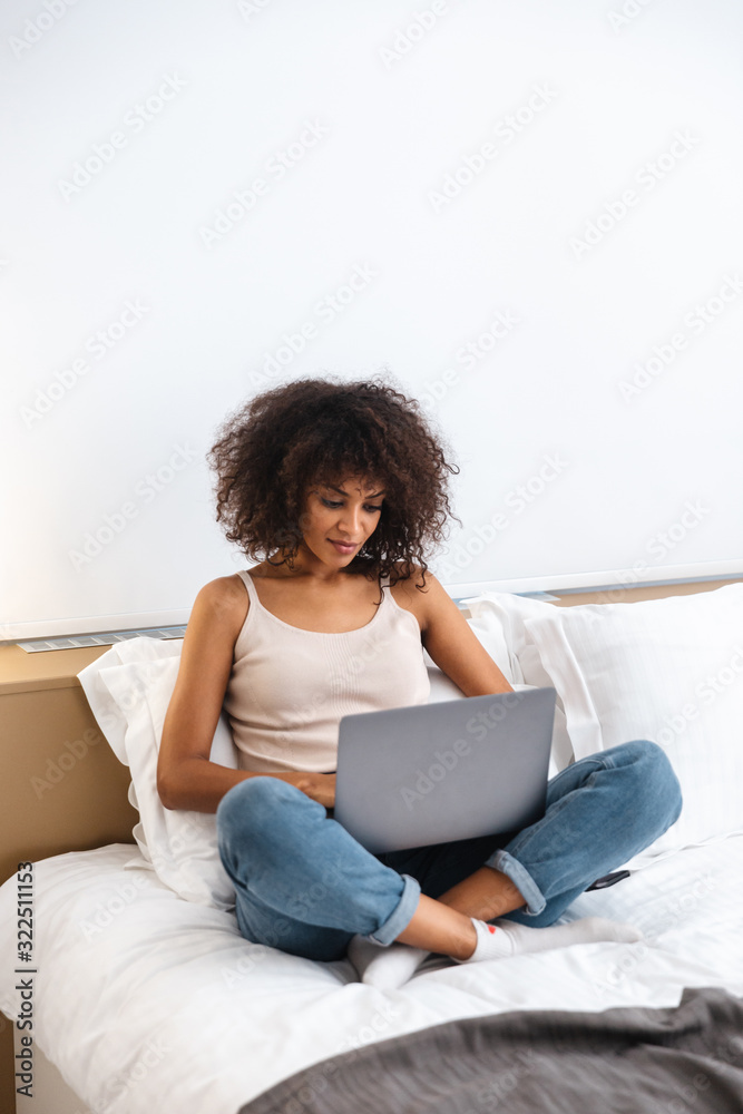 African woman indoors at home using laptop computer. African woman indoors at home using laptop computer.