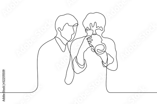 men who just took a photo look into a professional camera. One continuous line art two friend men check a photograph.
