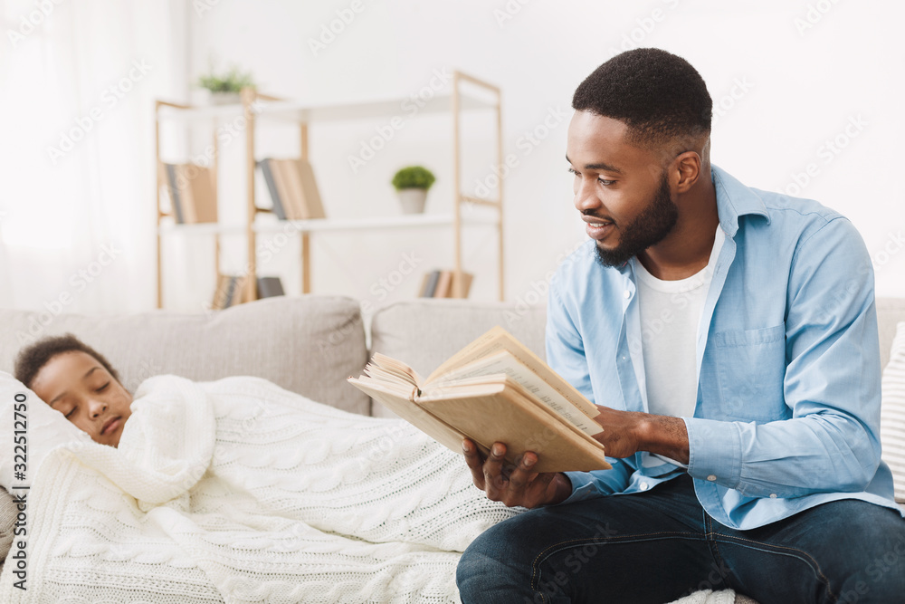 African daddy reading book for his sleeping daughter