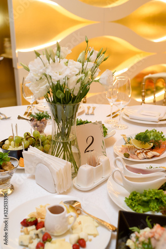 Table setting with meal and flowers on table, copy space. Place setting at wedding reception. Table served for wedding banquet in restaurant