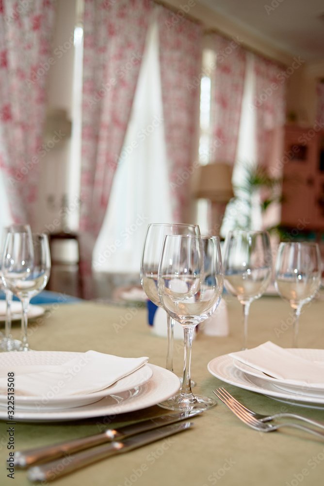 Table set with plates, wineglasses and cutlery on table, copy space. Place setting at wedding reception. Table served for wedding banquet in restaurant Table set with plates, wineglasses and cutlery on table, copy space. Place setting at wedding reception. Table served for wedding banquet in restaurant