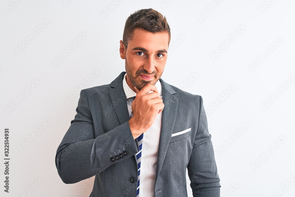 Young handsome business man wearing suit and tie over isolated background looking confident at the camera smiling with crossed arms and hand raised on chin. Thinking positive. Young handsome business man wearing suit and tie over isolated background looking confident at the camera smiling with crossed arms and hand raised on chin. Thinking positive.