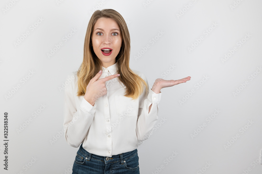 young beatuiful blond woman showing direction with her hands, pointing with finger direction, standing on isolated white background young beatuiful blond woman showing direction with her hands, pointing with finger direction, standing on isolated white background