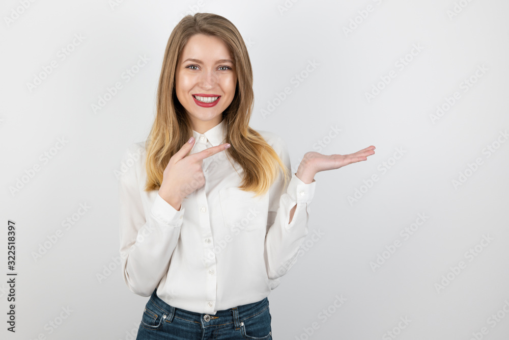 young smiling blond woman showing direction with her hands, pointing with finger the way, standing on isolated white background young smiling blond woman showing direction with her hands, pointing with finger the way, standing on isolated white background